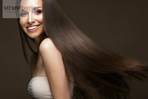 Schönes brünettes Mädchen in Bewegung mit einem perfekt glatten Haar  und klassisches Make-up. Schönes Gesicht. Bild im Studio aufgenommen