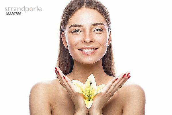 Schönes junges Mädchen mit einem leichten natürlichen Make-up und perfekter Haut mit Blumen in der Hand. Schönes Gesicht. Bild im Studio auf einem weißen Hintergrund aufgenommen