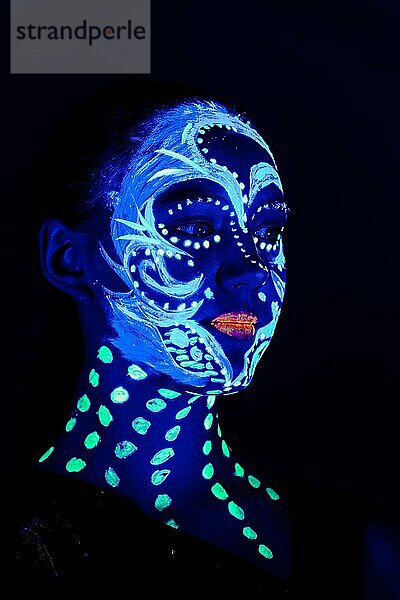 Porträt eines schönen Mädchens mit ultravioletter Farbe im Gesicht. Mädchen mit Neon-Make-up in Farbe Licht