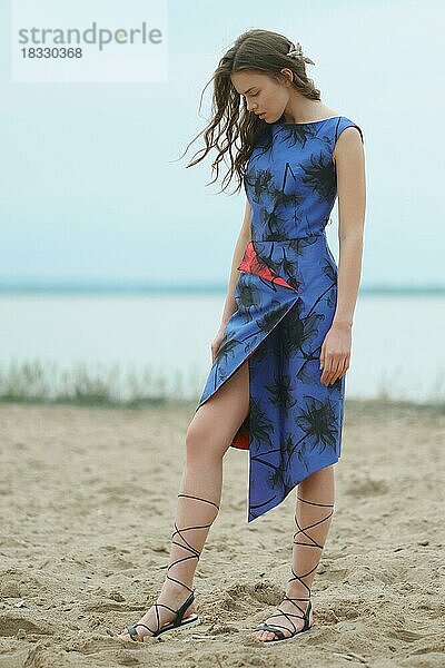 Lifestyle-Porträt einer jungen Frau  die auf dem Sand spazieren geht