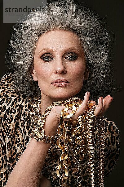 Porträt einer schönen älteren Frau in einer Leopardenbluse mit klassischem Make-up und grauem Haar