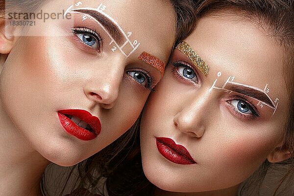 Zwei Mädchen sind Zwillingsschwestern mit einem ungewöhnlichen Augenbrauen-Make-up. Schönes Gesicht. Foto im Studio aufgenommen
