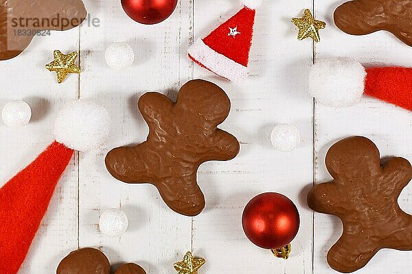 Mit Schokolade glasierte deutsche Lebkuchen in Form von Männern zwischen Weihnachtsdekoration