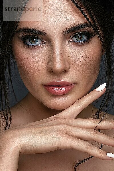 Schönes Mädchen mit hellen modischen Make-up  Sommersprossen und blauen Augen. Schönes Gesicht. Foto im Studio aufgenommen