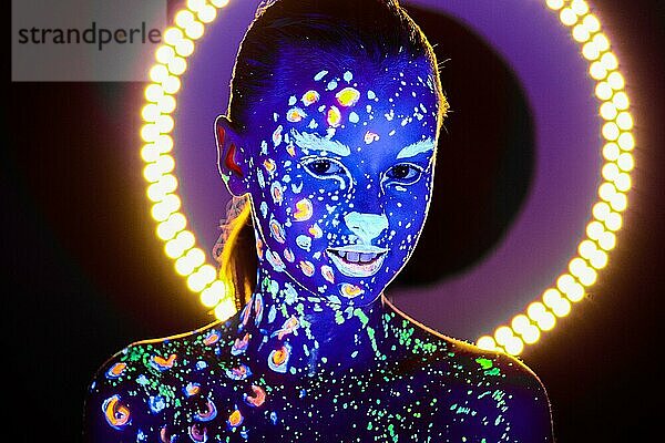 Porträt eines schönen Mädchens mit ultravioletter Farbe im Gesicht. Mädchen mit Neon-Make-up in Farbe Licht