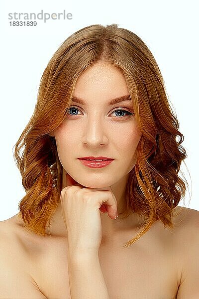 Porträt einer schönen jungen Frau mit blauen Augen und roten Lippen  die ihr Kinn berühren. Schönheit Porträt  frische Haut. Natürliches Make-up