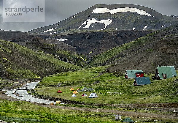 Zelte und Hütten zwischen Vulkanlandschaft mit schwarzem Sand und grünem Gras  Ásgarður  Kerlingarfjöll  isländisches Hochland  Island  Europa