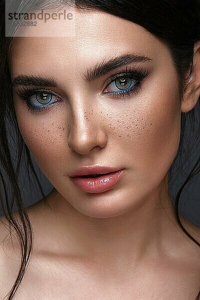 Schönes Mädchen mit hellen modischen Make-up  Sommersprossen und blauen Augen. Schönes Gesicht. Foto im Studio aufgenommen