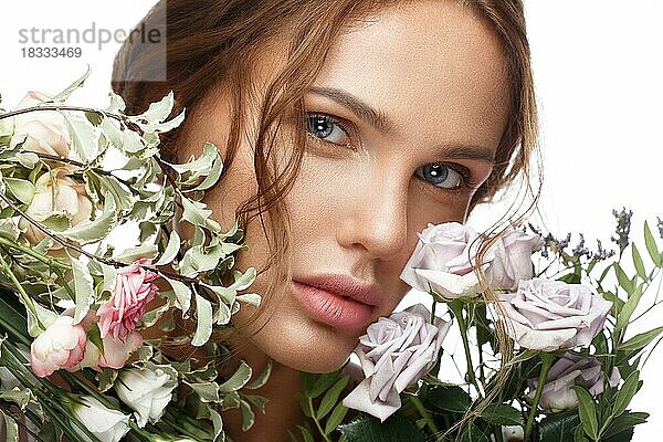 Schöne Frau mit klassischem Nackt-Make-up  heller Frisur und Blumen. Schönes Gesicht. Foto im Studio aufgenommen