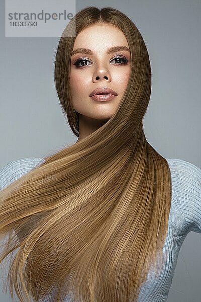 Schönes blondes Mädchen mit einem perfekt glatten Haar und klassischem Make-up. Schönheit Gesicht und Haar. Bild im Studio aufgenommen