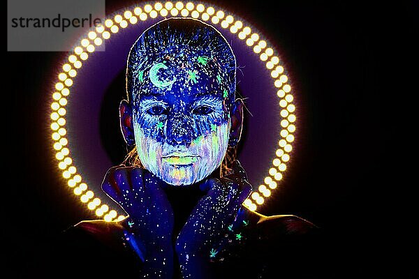 Porträt eines schönen Mädchens mit ultravioletter Farbe im Gesicht. Mädchen mit Neon-Make-up in Farbe Licht