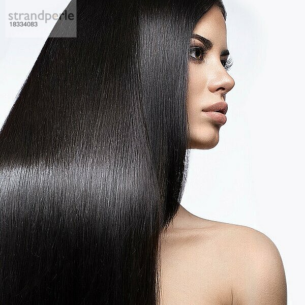 Schönes brünettes Mädchen in Bewegung mit einem perfekt glatten Haar  und klassisches Make-up. Schönheit Gesicht. Bild im Studio auf einem weißen Hintergrund genommen