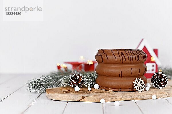 Traditioneller deutscher Winterkuchen  bei dem die Schichten im Inneren mit Schokolade glasiert und mit jahreszeitlicher Dekoration umgeben sind  genannt Baumkuchen