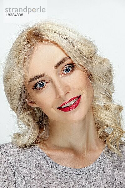 Weißhaariges Modemodell mit natürlichem Make-up  Lockenfrisur  blauen Augen und roten Lippen