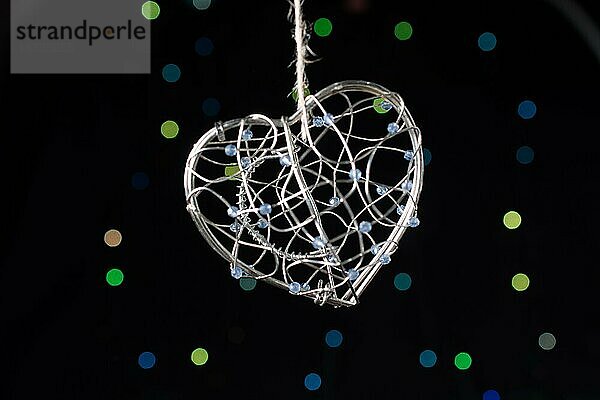 Herzförmige Metallkäfig auf einem Bokeh Licht Hintergrund