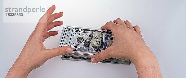 Menschliche Hand hält amerikanischen Dollar-Schein als Geld vor weißem Hintergrund