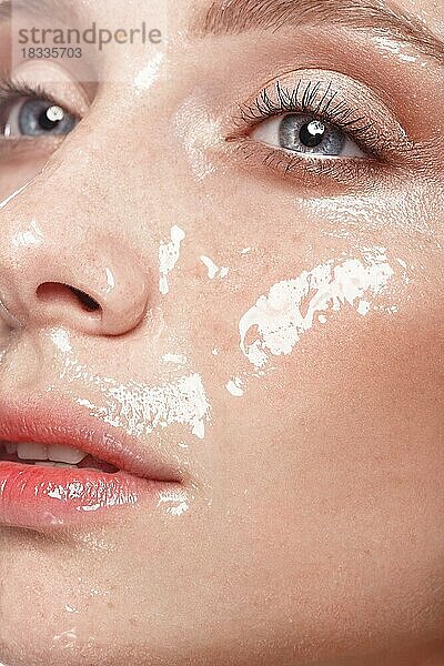 Schönes junges Mädchen mit leichtem Natur-Make-up und perfekter feuchter Haut. Schönes Gesicht. Bild im Studio auf einem weißen Hintergrund aufgenommen