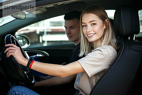 Der Fahrer ist ein Fahrschullehrer und eine Studentin in einem Prüfungswagen. Lektion auf der Rennstrecke