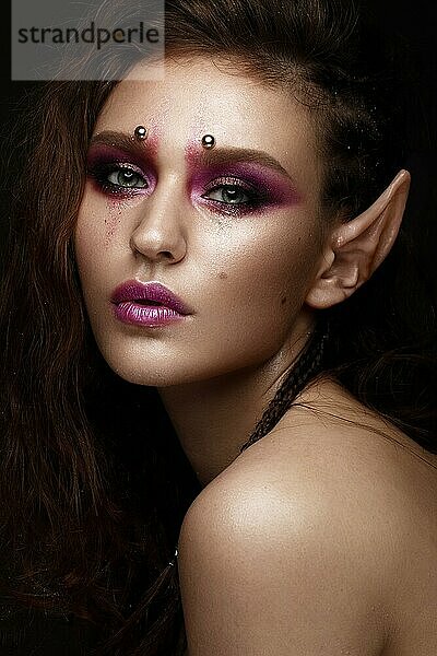 Brünettes Mädchen mit einer kreativen Frisur Zöpfe  Kunst Make-up und die Ohren der Elfe. Schönheit Gesicht. Foto im Studio aufgenommen