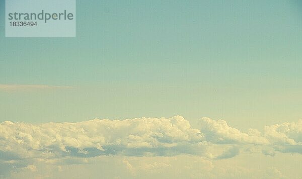 Weiße Farbwolken bedecken den blauen Himmel am Tag