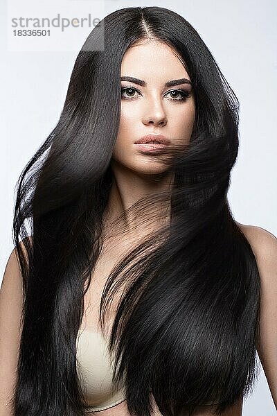 Schönes brünettes Mädchen in Bewegung mit einem perfekt glatten Haar  und klassisches Make-up. Schönheit Gesicht. Bild im Studio auf einem weißen Hintergrund genommen