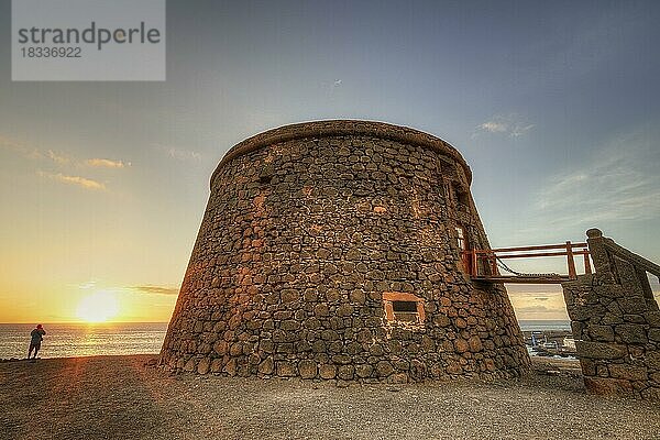 Castillo de Toston  runder Festungsturm  HDR  Gegenlicht  Sonnenuntergang  einzelner Mensch von hinten am Strand schaut auf Sonnenuntergang  Superweitwinkel  Westküste  Fuerteventura  Kanarische Inseln  Spanien  Europa