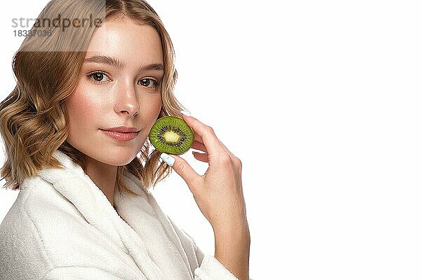 Schönes zartes junges Mädchen in einem weißen Mantel mit sauberer frischer Haut posiert vor der Kamera. Schönes Gesicht. Hautpflege. Foto im Studio auf einem weißen isolieren Hintergrund genommen