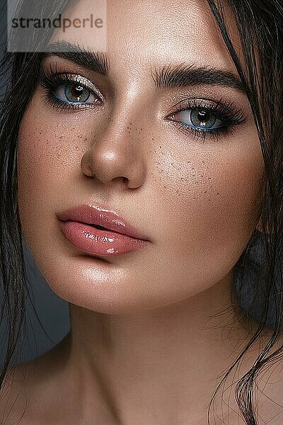 Schönes Mädchen mit hellen modischen Make-up  Sommersprossen und blauen Augen. Schönes Gesicht. Foto im Studio aufgenommen