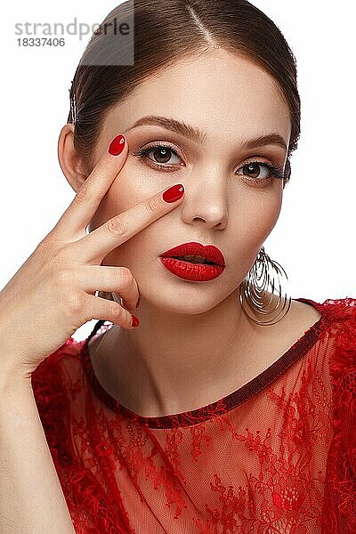 Schönes Mädchen in rotem Kleid mit klassischem Make-up und roter Maniküre. Schönes Gesicht. Foto im Studio aufgenommen