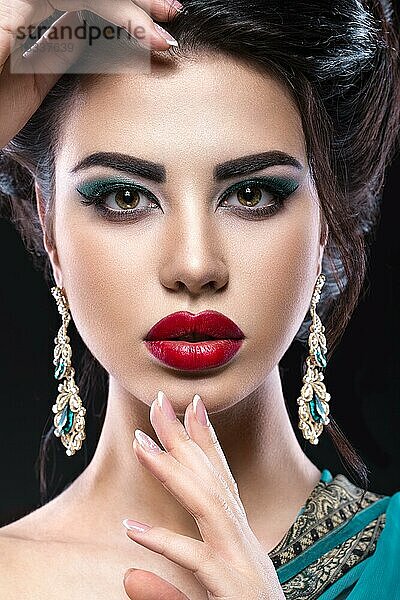 Schönes brünettes Mädchen mit arabischem Abend-Make-up und perfekter Haut. Schönes Gesicht. Nahaufnahme
