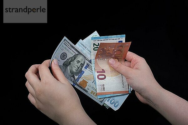 Hand hält amerikanische Dollar-Banknoten vorschwarzem Hintergrund
