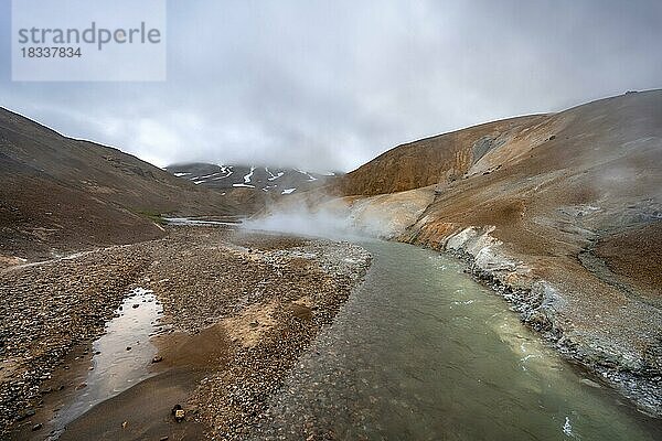 Dampfender Bach zwischen bunten Rhyolith Bergen mit Schneefeldern  Geothermalgebiet Hveradalir  Kerlingarfjöll  isländisches Hochland  Island  Europa