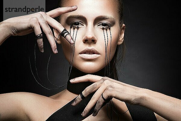 Schönes Mädchen mit kreativen Make-up im Gothic-Stil und die Fäden der Augen. Kunst Schönheit Gesicht. Bild im Studio auf einem schwarzen Hintergrund genommen