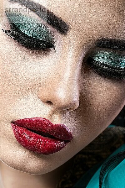 Schönes brünettes Mädchen mit arabischem Abend-Make-up und perfekter Haut. Schönes Gesicht. Nahaufnahme