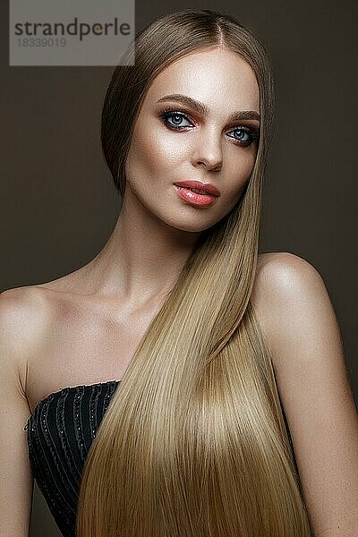 Schönes blondes Mädchen mit einem perfekt glatten Haar  klassisches Make-up. Schönes Gesicht. Bild im Studio auf einem weißen Hintergrund genommen