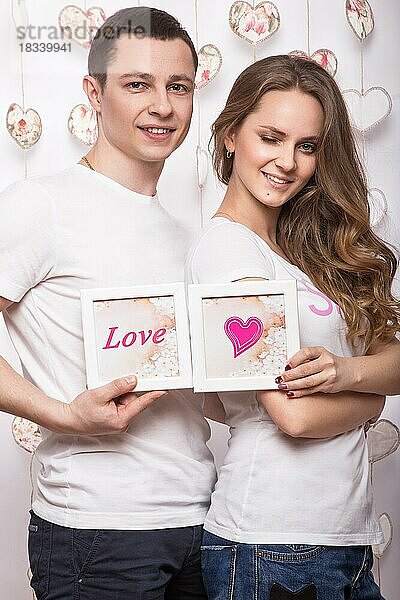 Junge  schöne Frau und Mann in der Liebe am Valentinstag  Laughing Happy Lovers  zeigt verschiedene Posen. Bild im Studio mit Dekorationen genommen