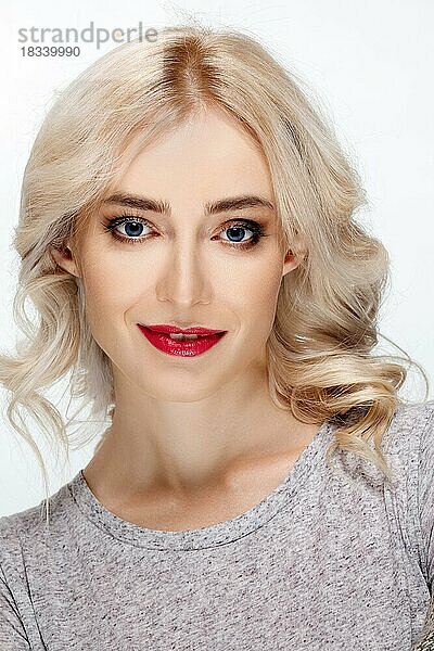 Weißhaariges Modemodell mit natürlichem Make-up  Lockenfrisur  blauen Augen und roten Lippen