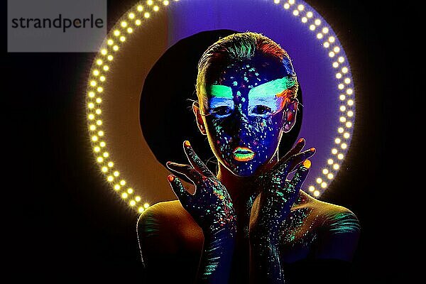 Porträt eines schönen Mädchens mit ultravioletter Farbe im Gesicht. Mädchen mit Neon-Make-up in Farbe Licht