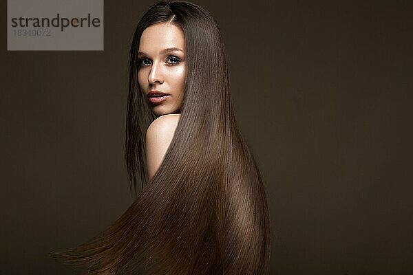 Schönes brünettes Mädchen in Bewegung mit einem perfekt glatten Haar  und klassisches Make-up. Schönes Gesicht. Bild im Studio aufgenommen