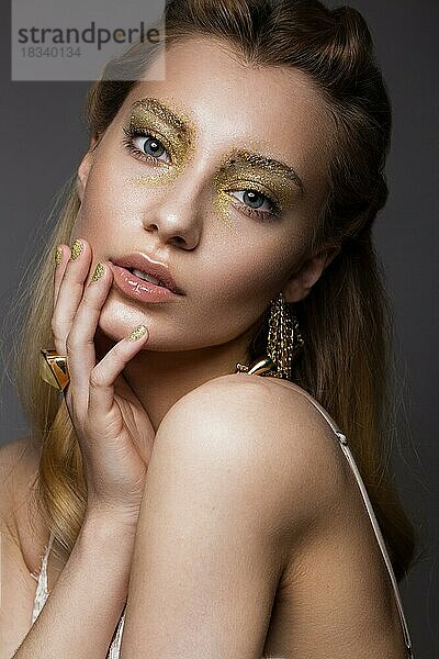 Schönes Mädchen in Unterwäsche mit kreativen Gold Make-up und Haar. Die Schönheit des Gesichts. Fotos im Studio geschossen