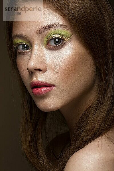 Schönes rothaariges Mädchen mit kreativem grünen Make-up. Schönes Gesicht. Fotos im Studio aufgenommen
