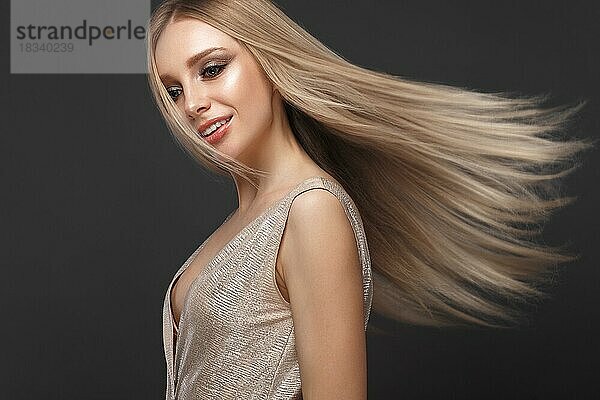 Schönes blondes Mädchen in Bewegung mit einem perfekt glatten Haar  und klassisches Make-up. Schönes Gesicht. Bild im Studio aufgenommen