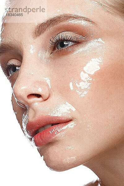 Schönes junges Mädchen mit leichtem Natur-Make-up und perfekter feuchter Haut. Schönes Gesicht. Bild im Studio auf einem weißen Hintergrund aufgenommen