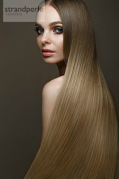 Schönes blondes Mädchen mit einem perfekt glatten Haar  klassisches Make-up. Schönes Gesicht. Bild im Studio auf einem weißen Hintergrund genommen