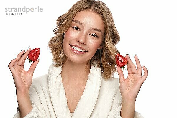 Schönes zartes junges Mädchen in einem weißen Mantel mit sauberer frischer Haut posiert vor der Kamera. Schönes Gesicht. Hautpflege. Foto im Studio auf einem weißen isolieren Hintergrund genommen