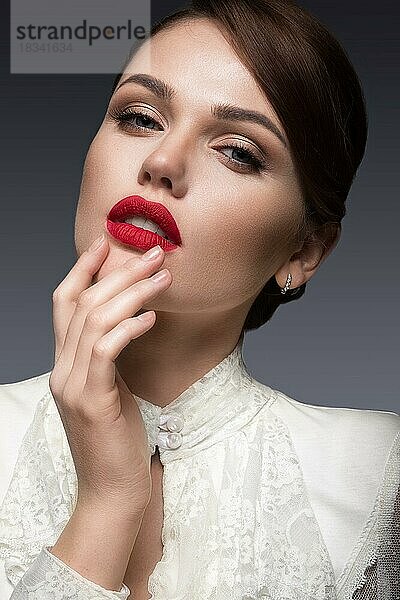 Schönes Mädchen mit roten Lippen in weißer Kleidung in der Form von Retro. Schönheit Gesicht. Bild im Studio aufgenommen