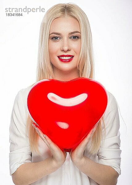 Liebe und Valentinstag  Frau hält Herzen lächelnd niedlich. Porträt der schönen Frau mit hellen Make-up und rotes Herz in der Hand
