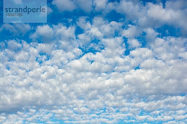 Weiße Farbwolken bedecken den blauen Himmel am Tag