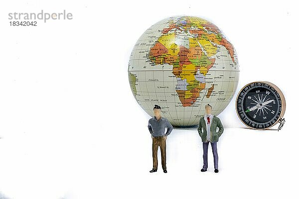 Ein Paar an der Seite eines Globus mit einem Kompass auf isoliertem weißen Hintergrund