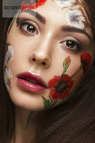 Schönes brünettes Mädchen mit Locken und einem Blumenmuster im Gesicht. Schönheit Blumen. Porträtaufnahme im Studio
